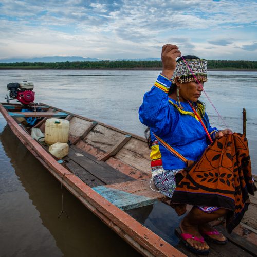 A woman working on traditional handicraft on a canoe in Nii Kaniti, Peru.